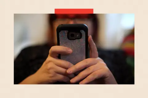 PA Wire A woman uses her mobile phone