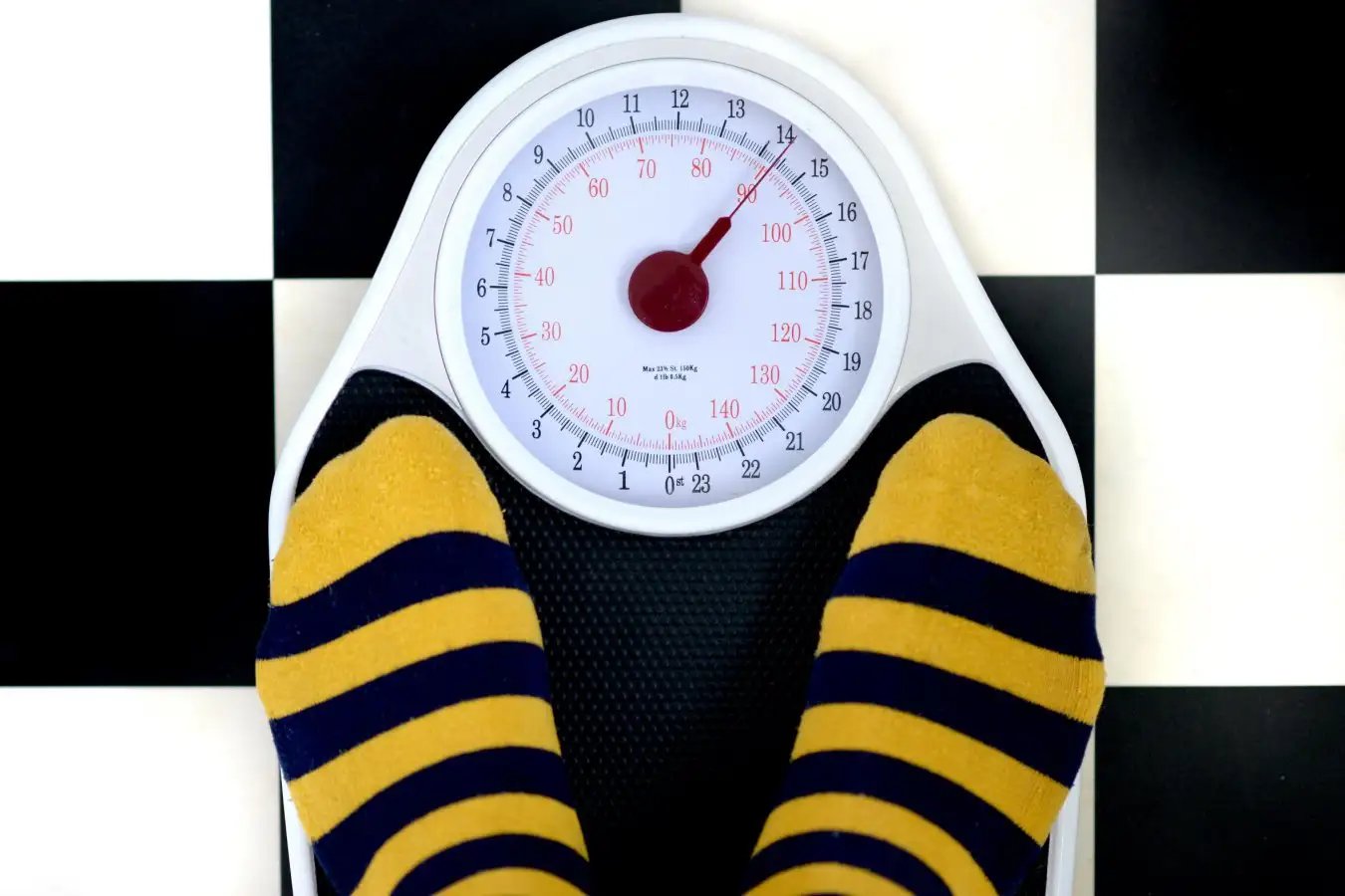 G0Y3BW Bathroom scales on checkered floor