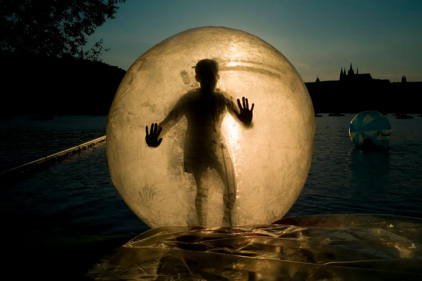 A tourist enjoys a zorb ball on the Vltava river.