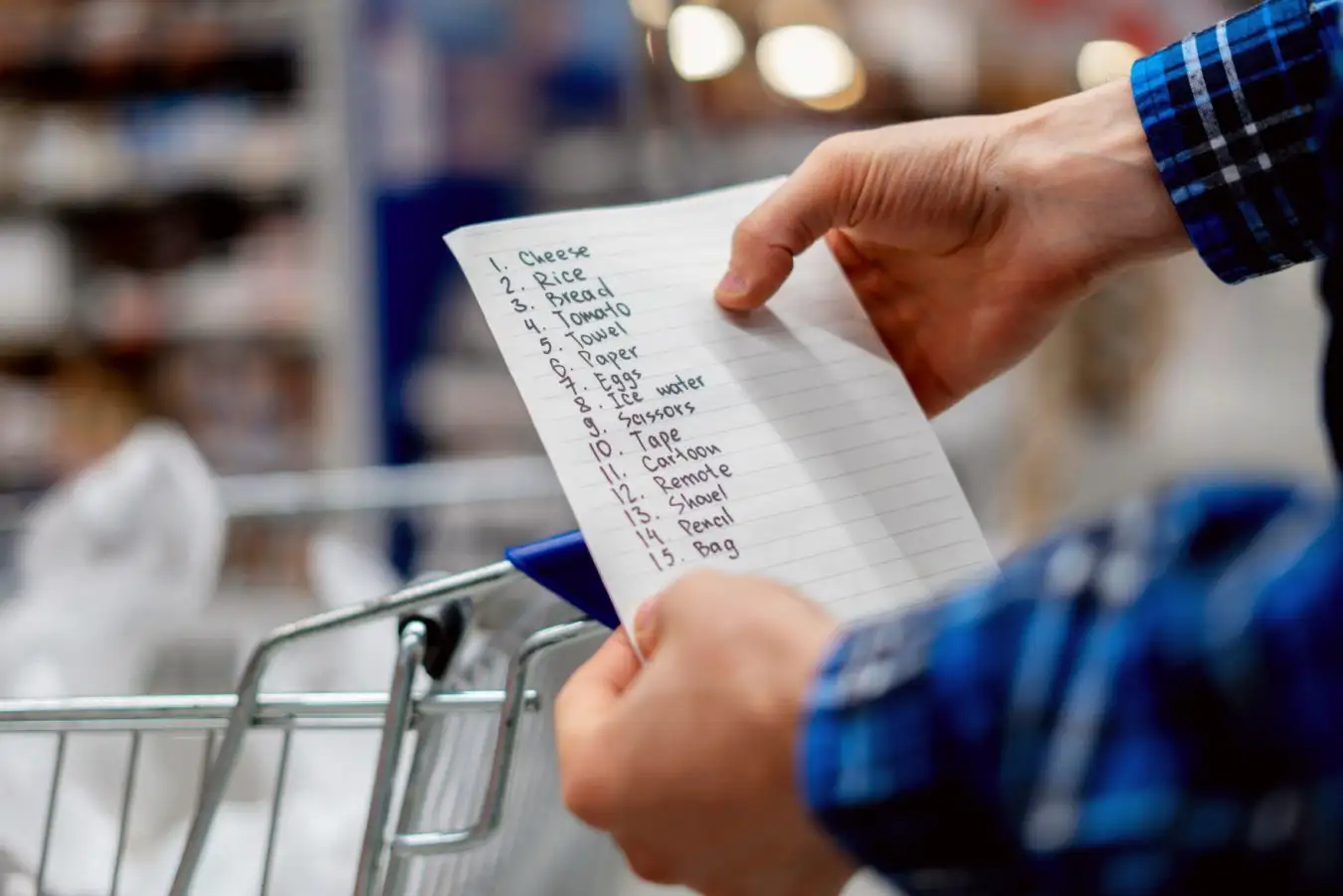 a person's hands holding a shopping list 
