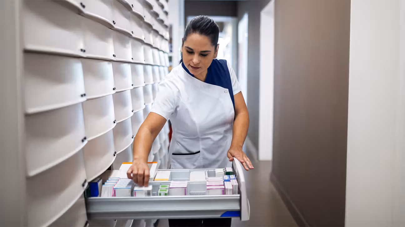 Pharmacist rifling through medication storage drawers