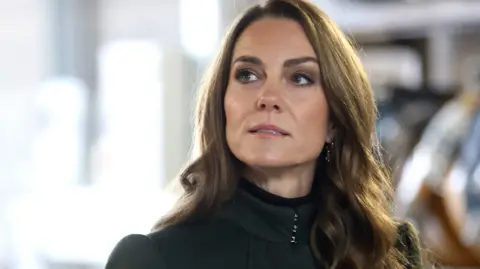 PA Media The Princess of Wales looks off into the distance. She's wearing a dark green coat.