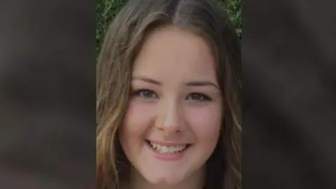 Family handout Emily Moore smiling at the camera. She has light brown hair.