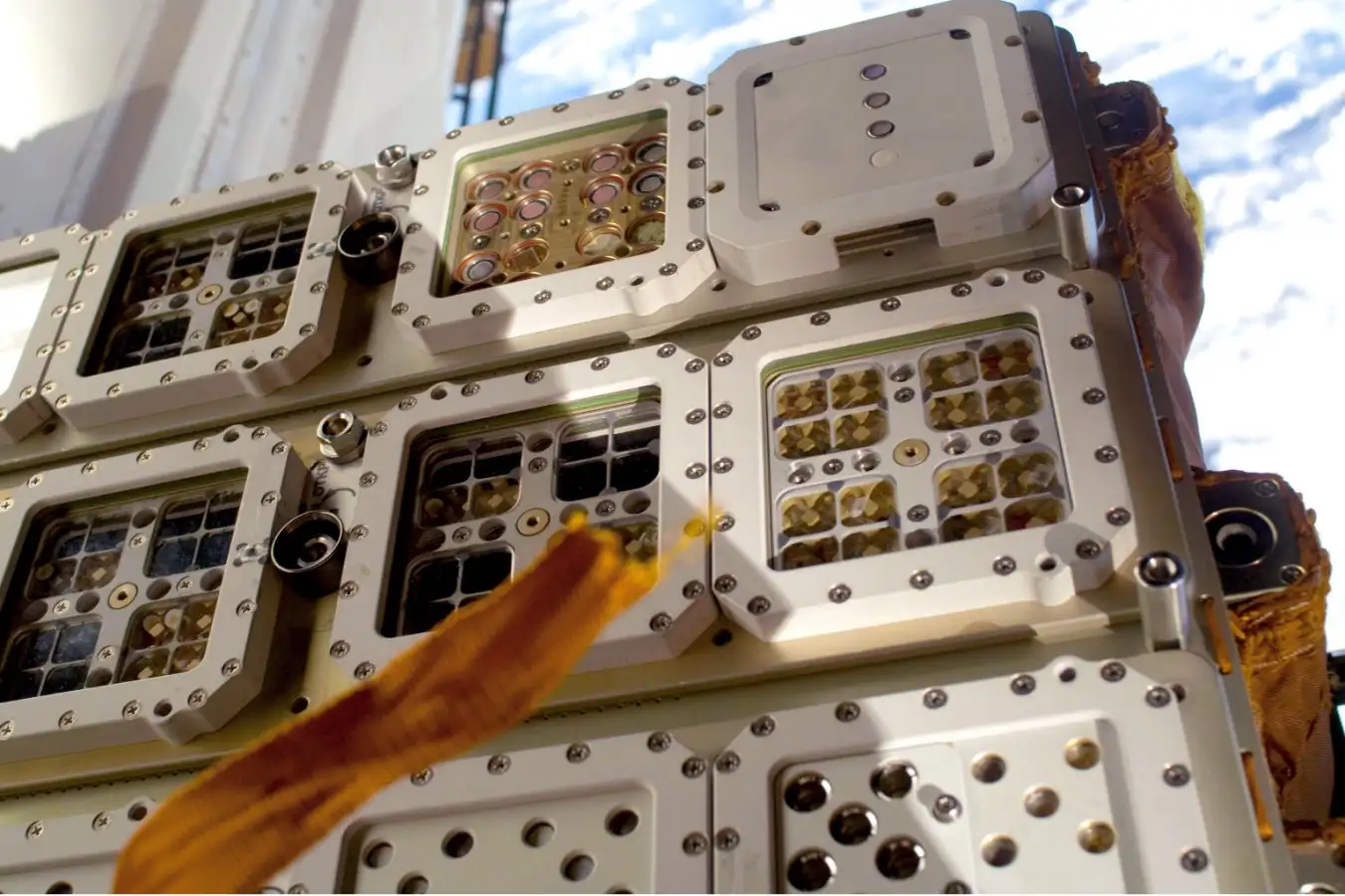 Closeup of Expose-E experiment module of the International Space Station. Small compartments, containing lichen samples, shows them happily thriving in this harsh environment in space.