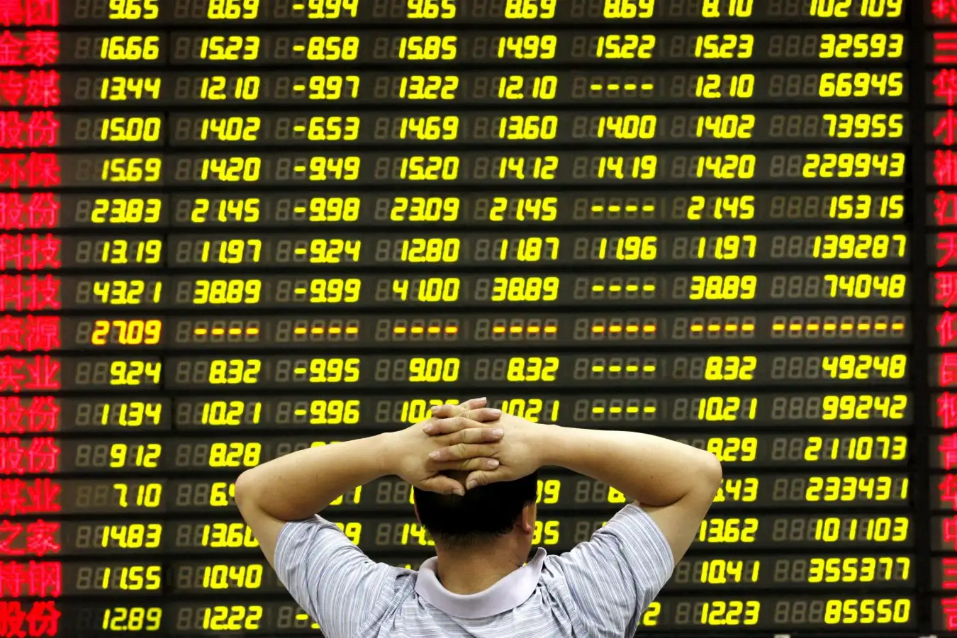An investor watches the monitor at a stock exchange in Huaibei, China