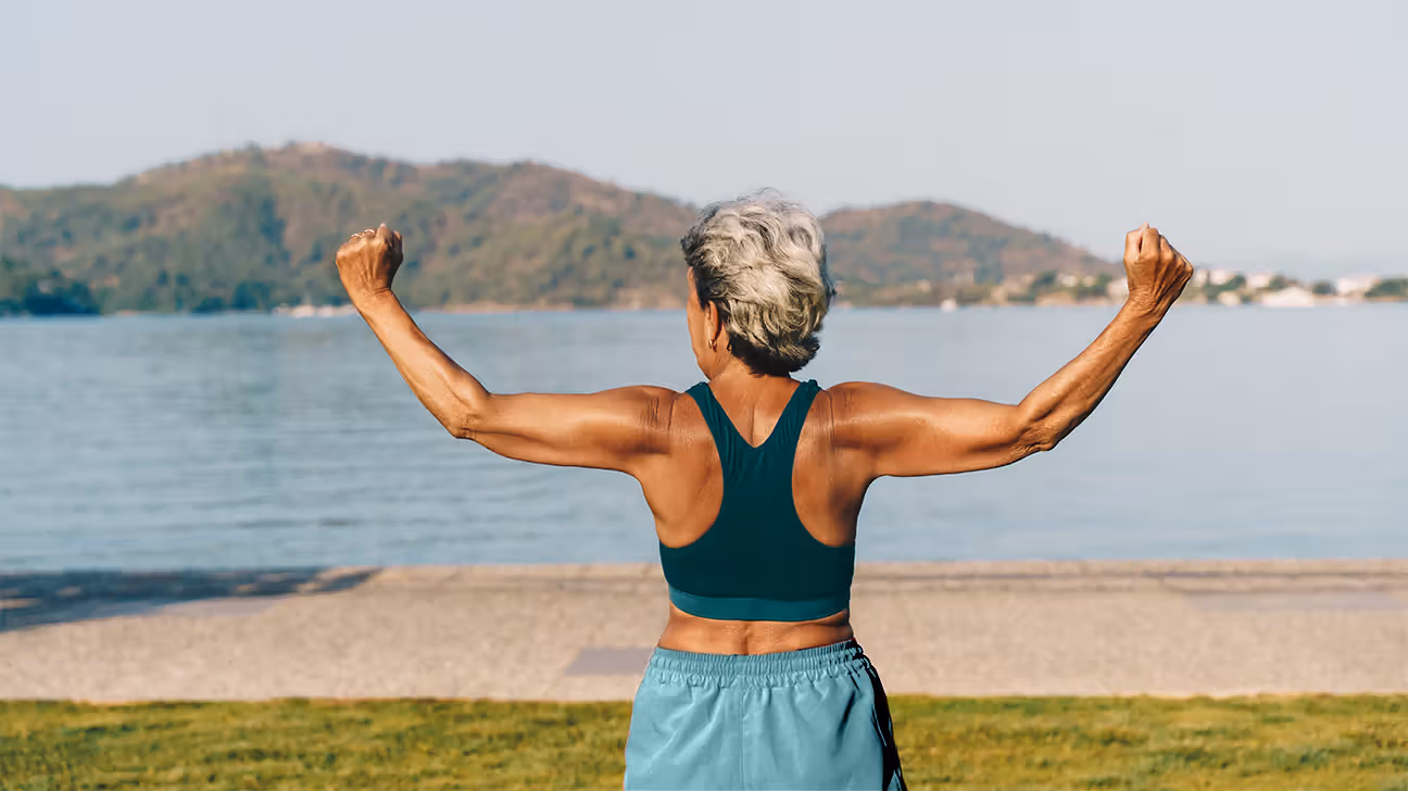 Older woman exercises outdoors by a lake