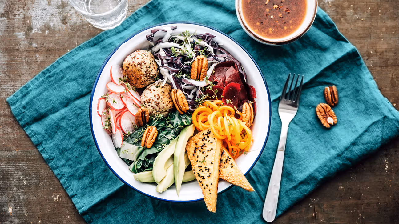 A bowl full of healthy foods on top of a teal cloth napkin
