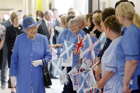 PA Media Queen Elizabeth smiles as she meets staff during a visit to the Royal Hospital for Sick Children in Glasgow in July 2015.