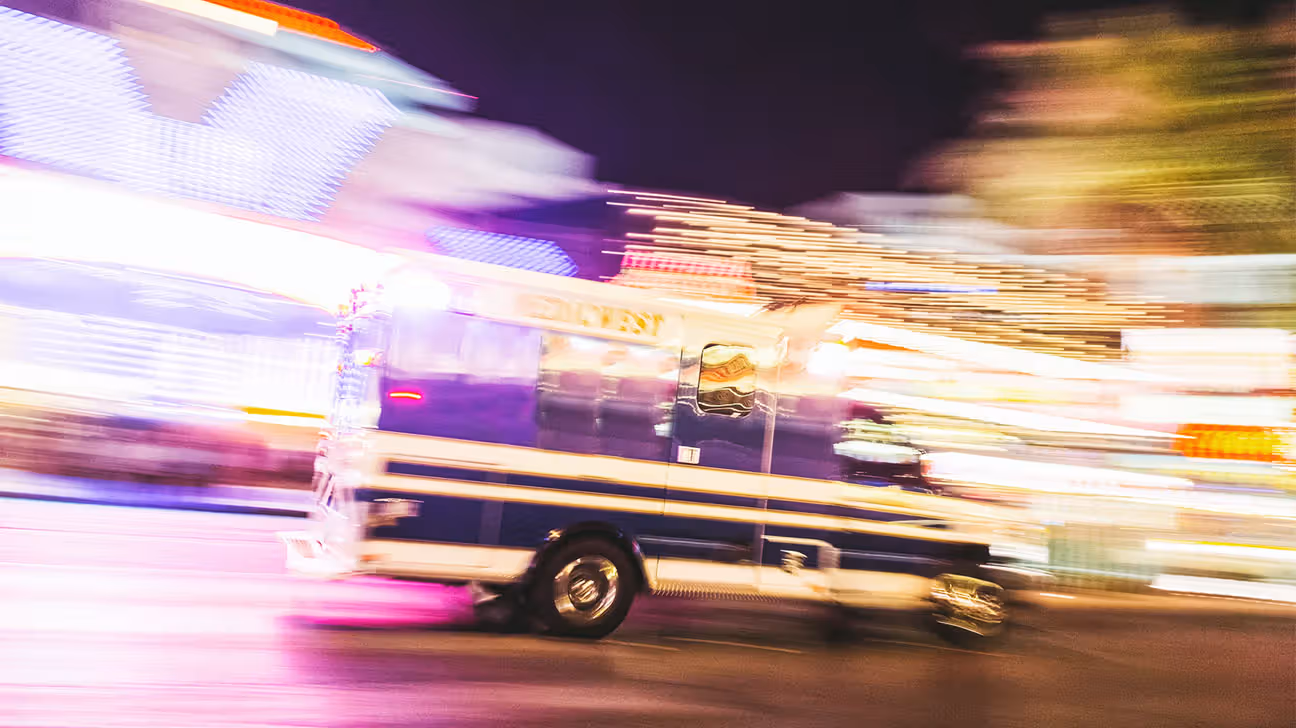Slightly blurred image of an ambulance driving down a street at night