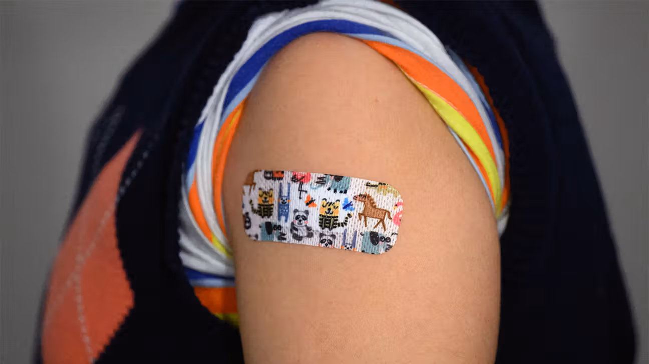 Animal print bandaid on child's arm after vaccination