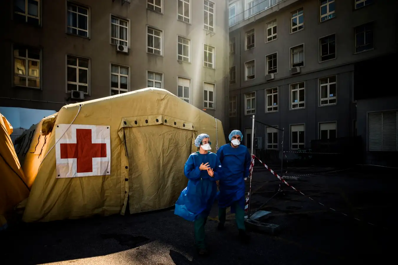 Health workers wearing face mask stand in front of a triage tent for suspected COVID-19 patients outside the Santa Maria Hospital in Lisbon on April 2, 2020. - Over 500 people have died in Portugal after contracting COVID-19 among more than 6,000 recorded cases of the disease. (Photo by PATRICIA DE MELO MOREIRA / AFP) (Photo by PATRICIA DE MELO MOREIRA/AFP via Getty Images)