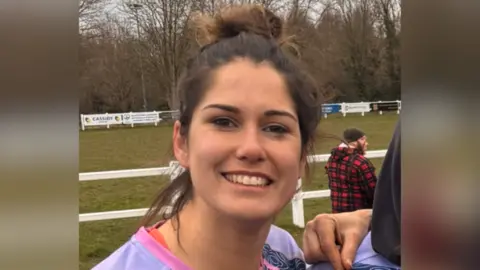 Annette Bevan A picture of Annette Bevan in her rugby kit, stood in front of a rugby pitch.