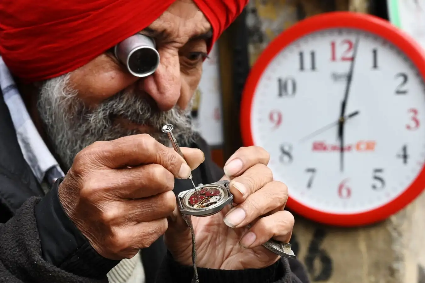 A clockmaker repairs a watch with small screwdriver. The ability to make these fine movements with our hands is a hallmark of our species