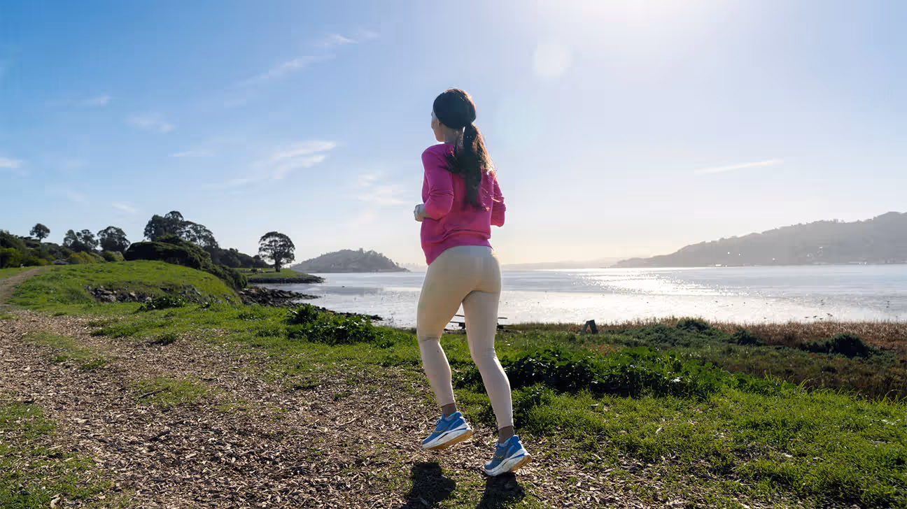 Female jogging outdoors near body of water