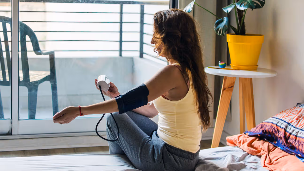 Younger female checking blood pressure at home