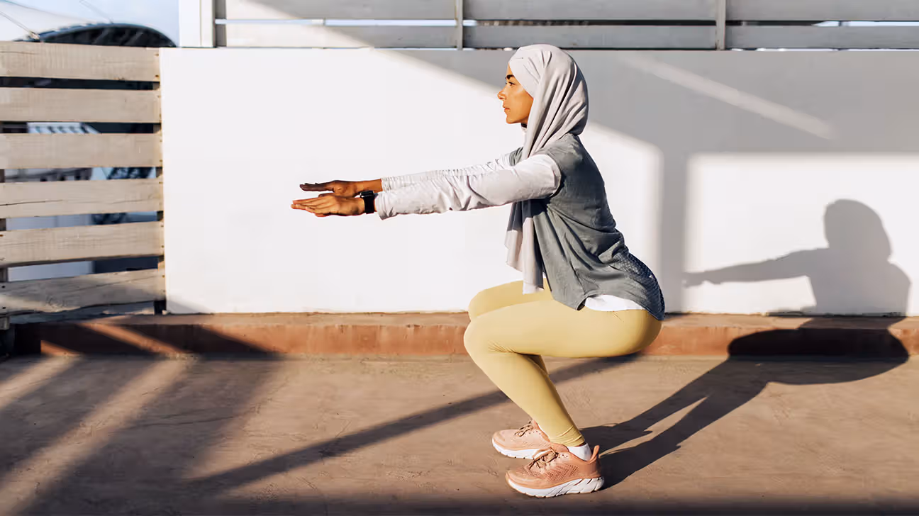 Female doing squats outside in the sunshine