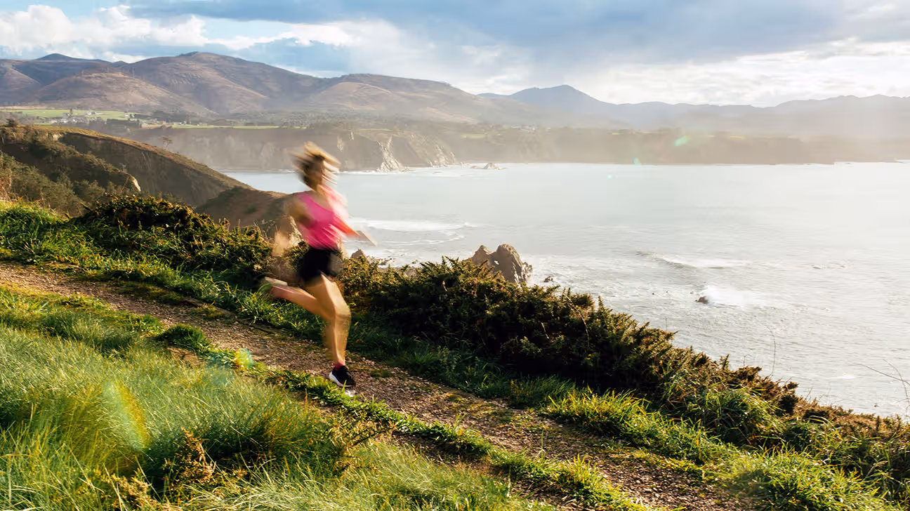 Female jogging outdoors on trail by ocean