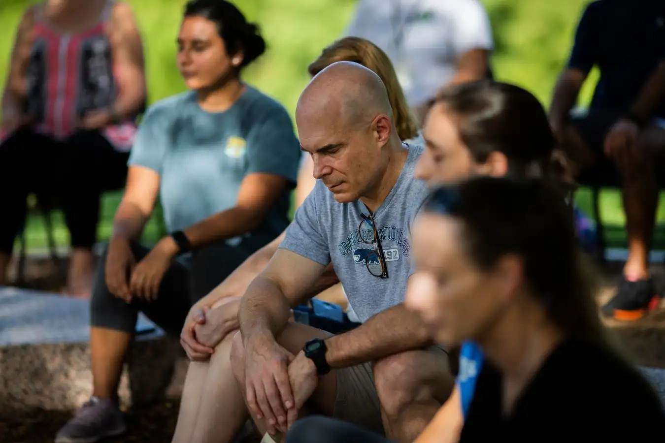 A group of people learn about mindfulness and meditation in a park