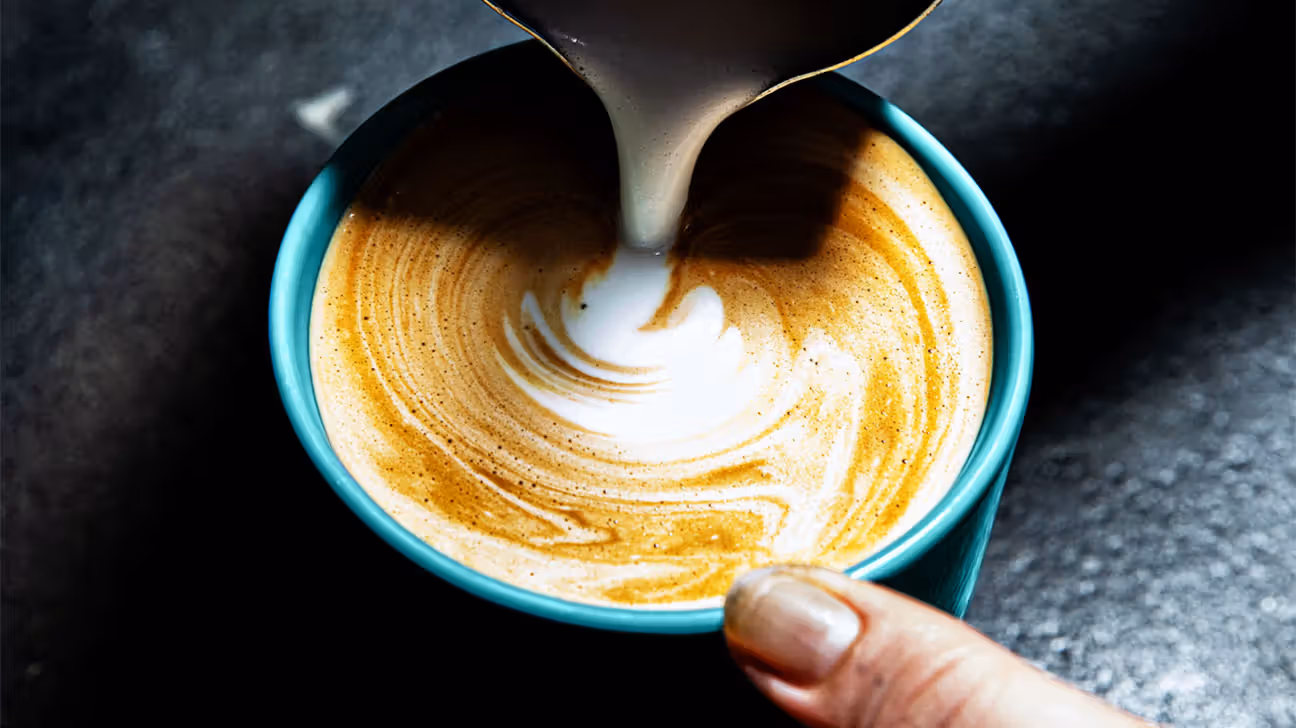 Pouring milk into a cappuccino 