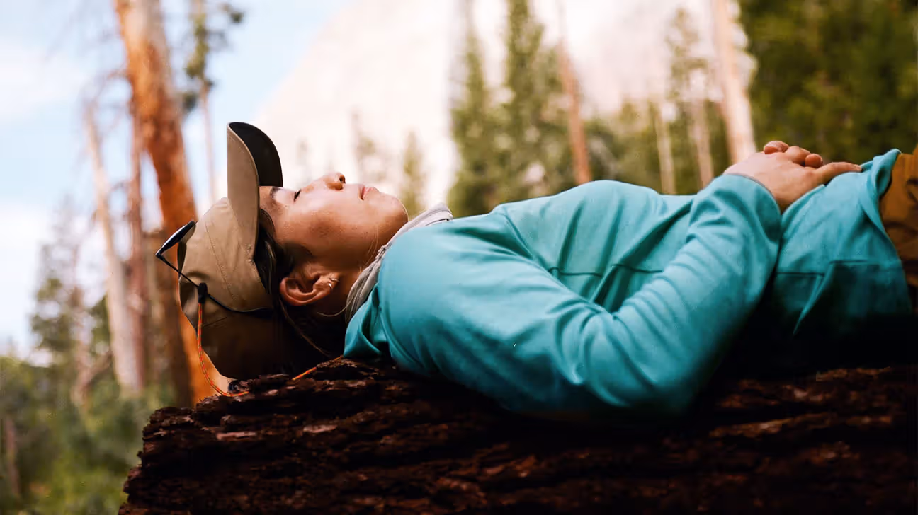 Hiker resting on tree outdoors