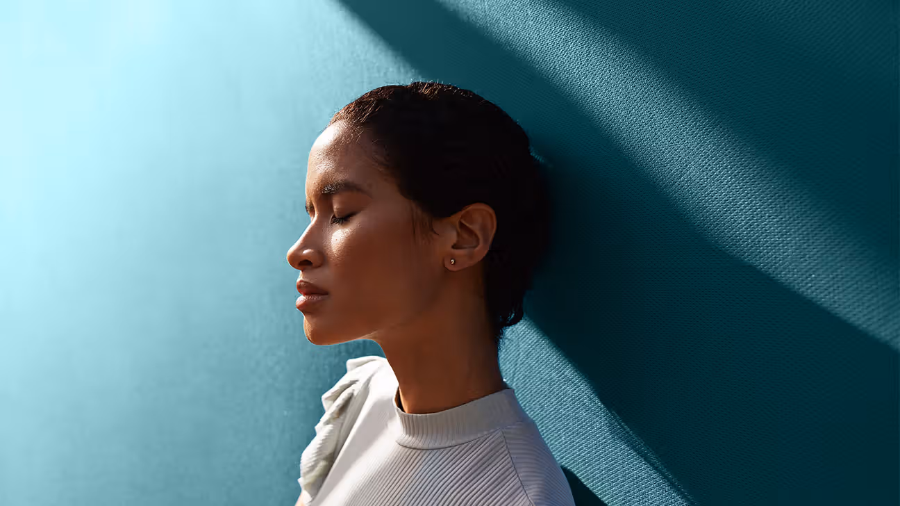 Female leaning against a blue wall