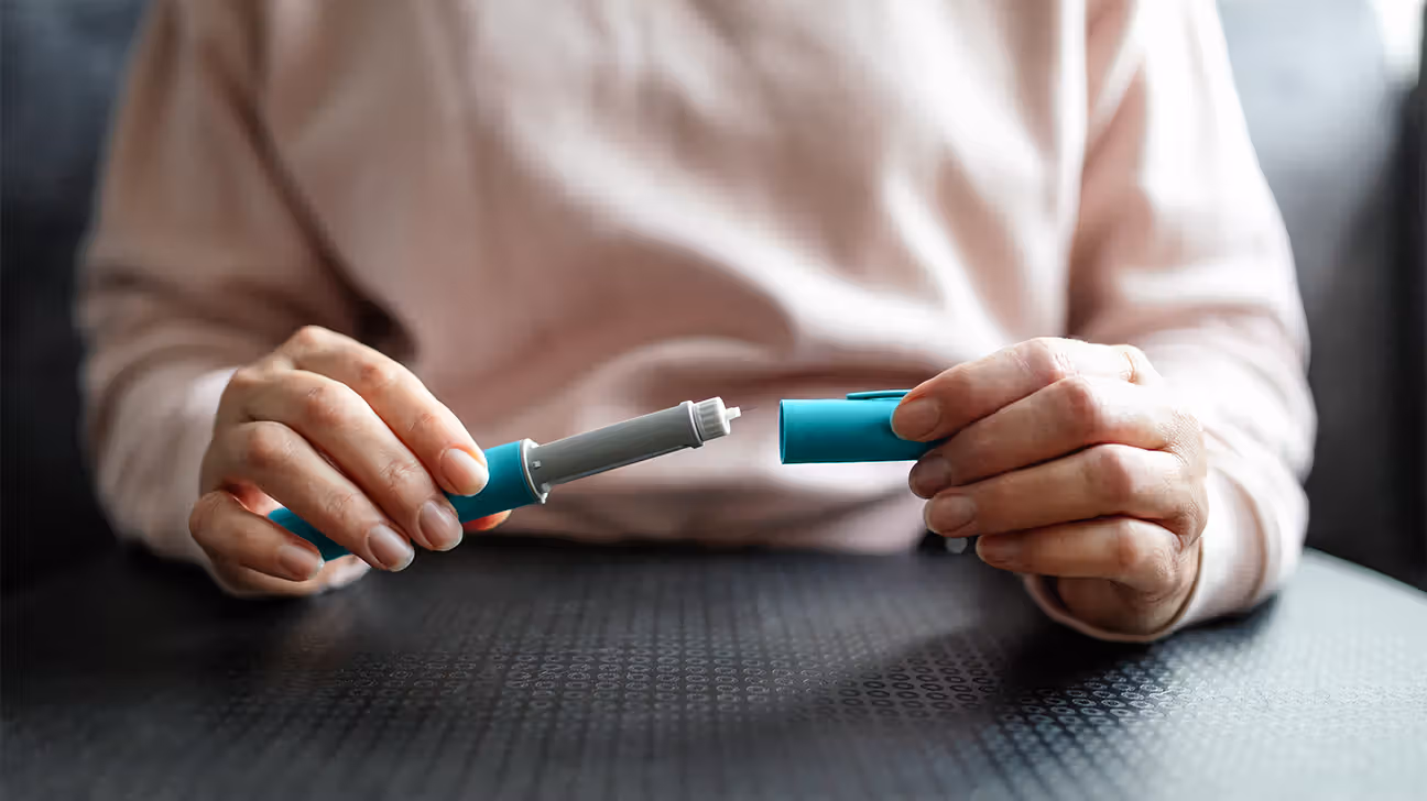 Closeup of a person holding a semaglutide injection pen