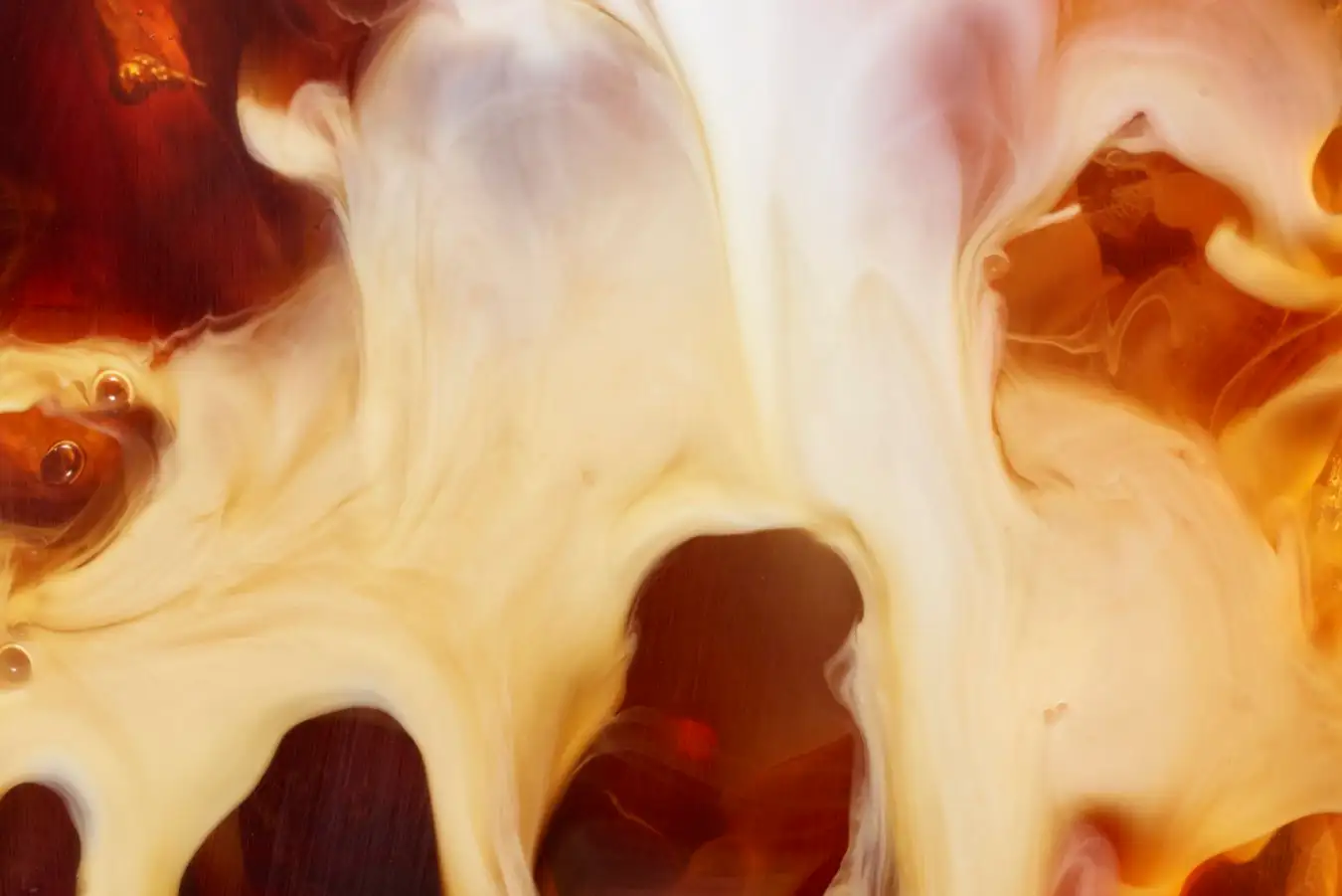 Milk poured over coffee. You see the turbulence of the two fluids as they mix together - swirls, eddies