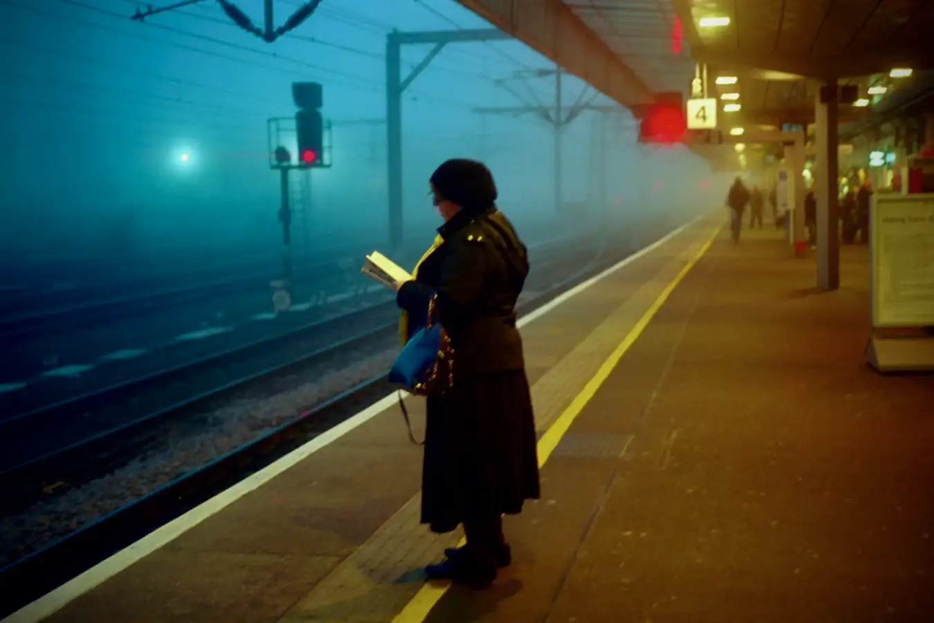 Commuter reading at Cambridge rail station.