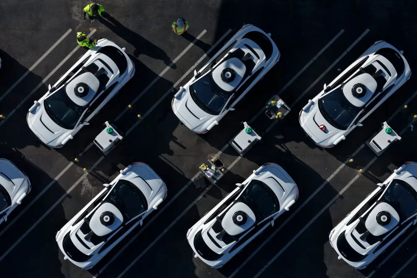 In an aerial view, Waymo robotaxis sit parked