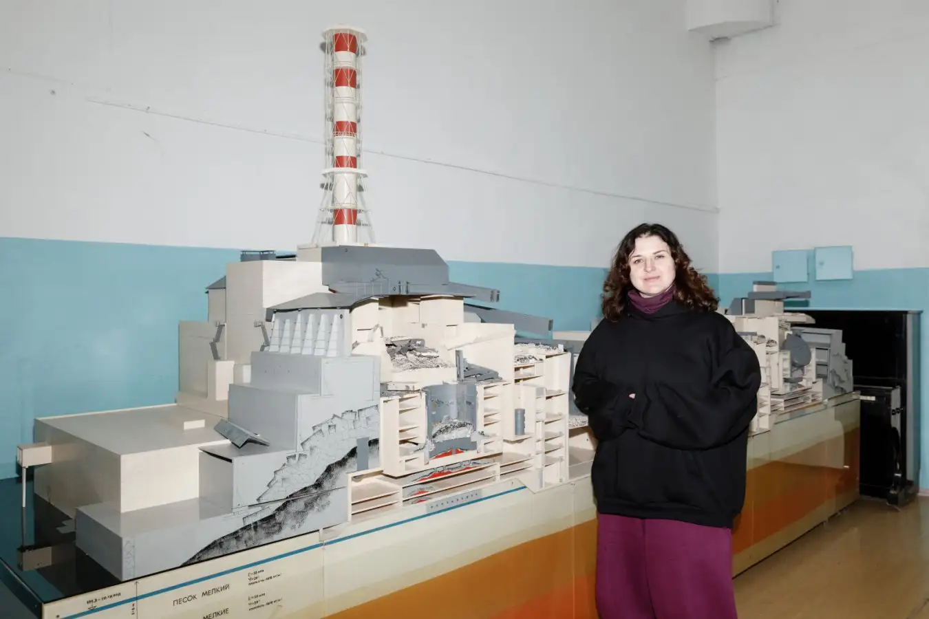 Radiobiologist Olena Pareniuk next to a model of the destroyed reactor 4