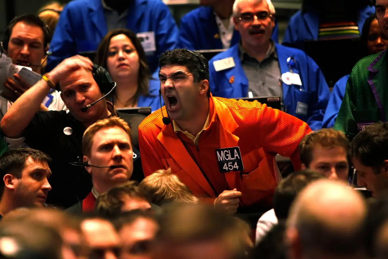 A trader yells angrily on a stock exchange floor.