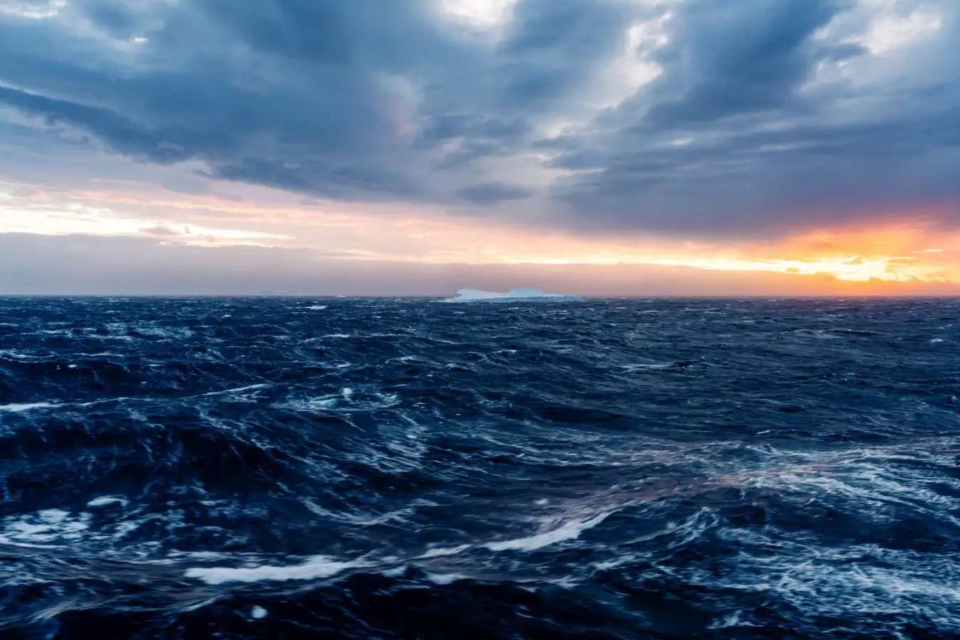 Iceberg in rough seas at sunset in Antarctica