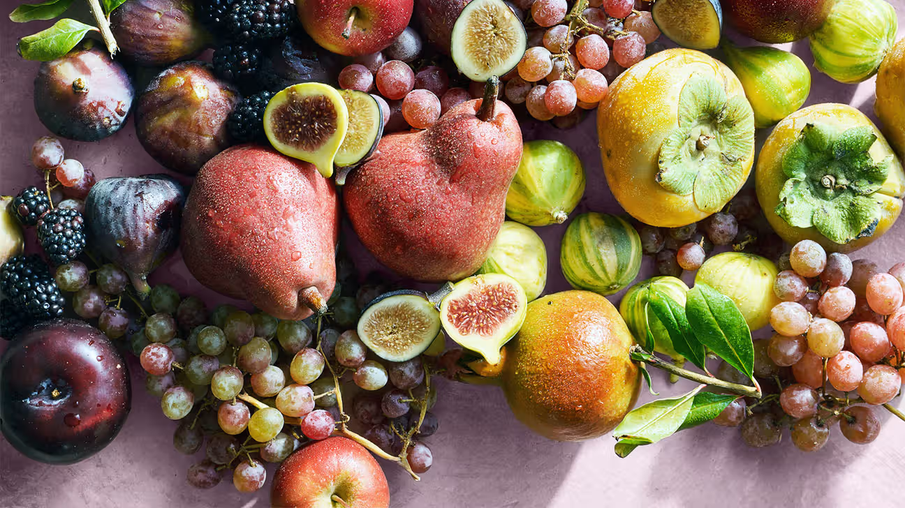 Various fruits against a pink background