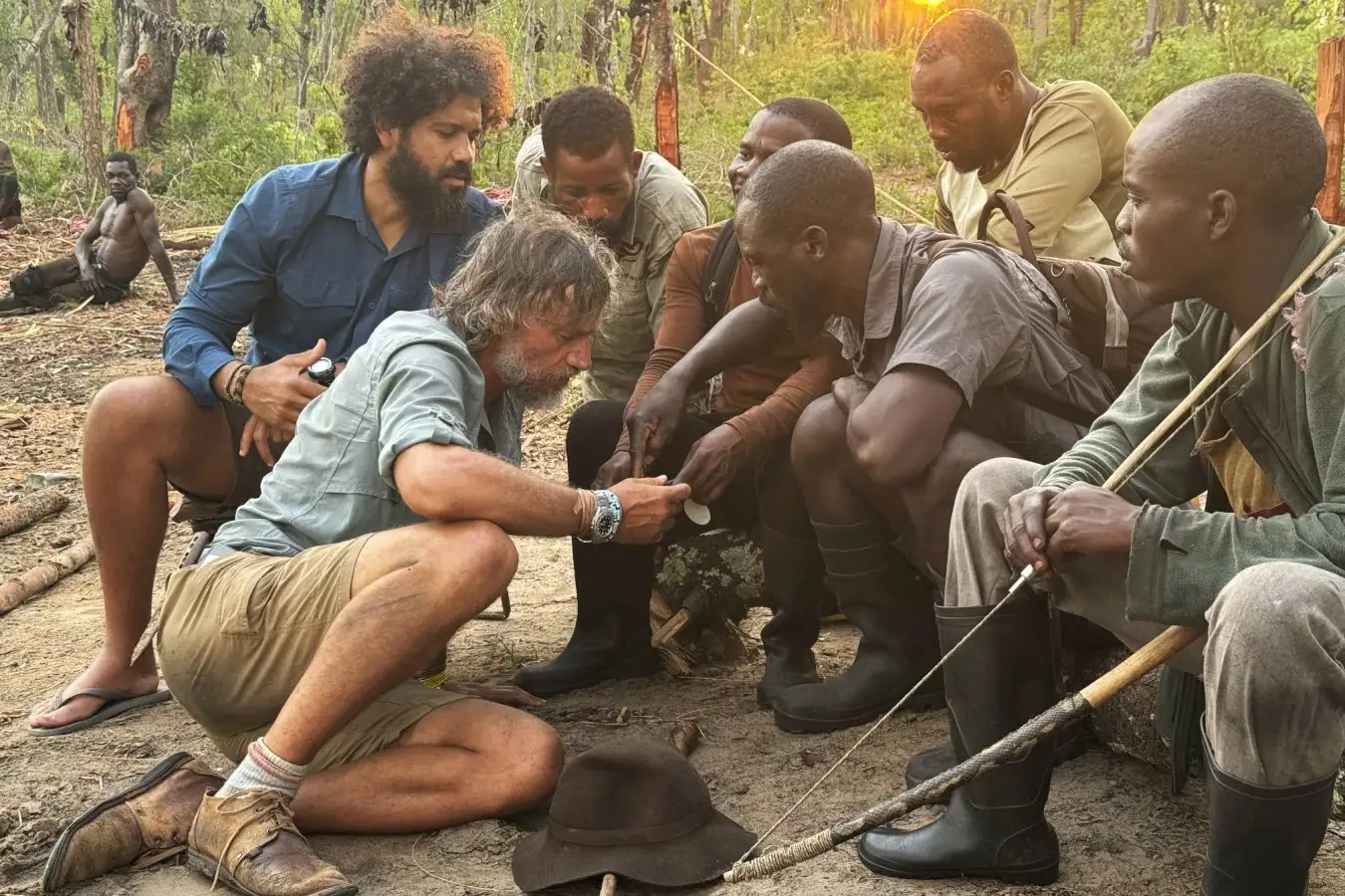 Kerllen Costa, Dr. Steve Boyes, and a group of Angolan tribal hunters check Steve's cellphone video of a ghost elephant at their search camp. (Credit: Ariel Leon Isacovitch) Ghost Elephants