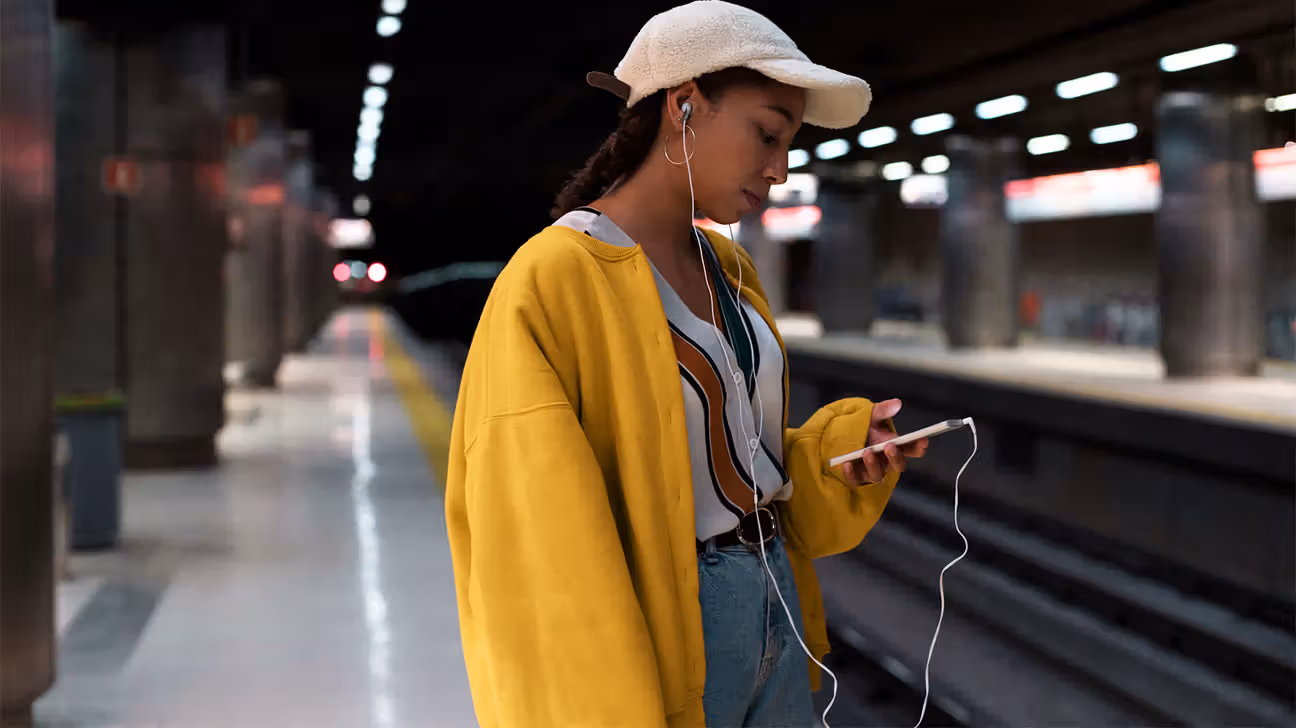 Young female scrolling on her phone in a subway station