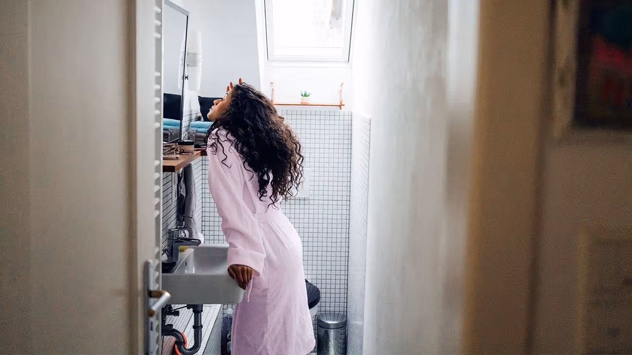 Female in pink robe in bathroom