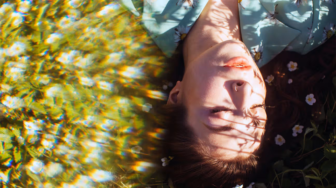 Hazy image of a female lying in the grass in the sunshine