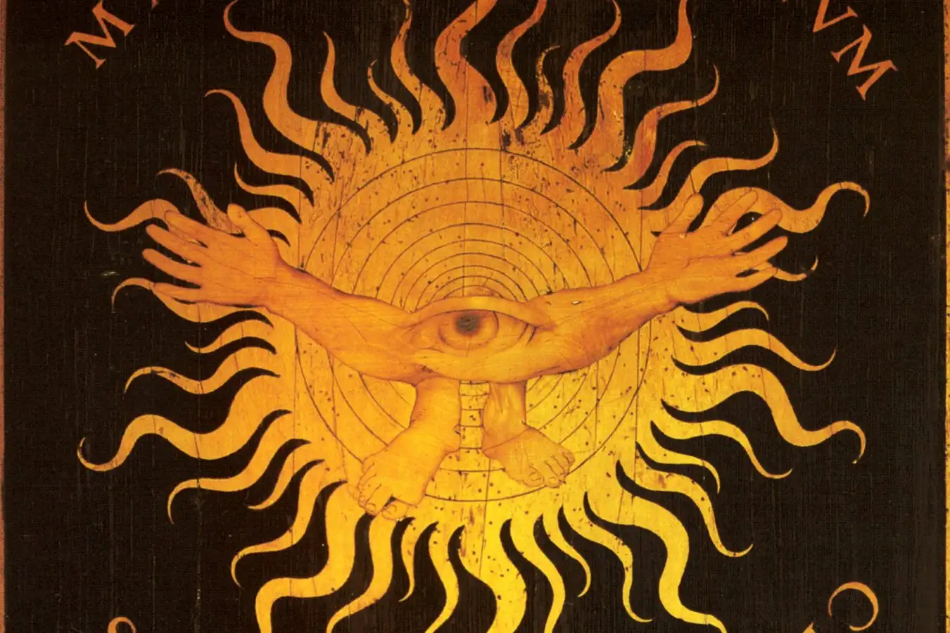 A wood inlay showing a strange being with two hands, two feet and a single eye, surrounded by 10 concentric circles and a ring of flames.