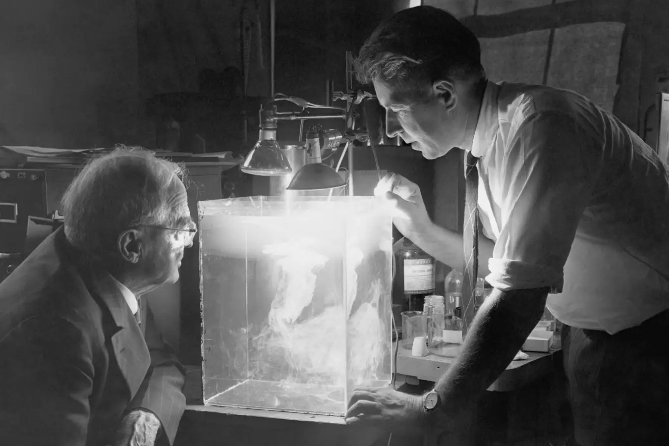 Dr. Willis R. Whitney, research director at the General Electric Company, watches Dr. Vincent J. Schaefer makes an artificial cloud in a plastic box. (Photo by ?????? Schenectady Museum; Hall of Electrical History Foundation/CORBIS/Corbis via Getty Images)