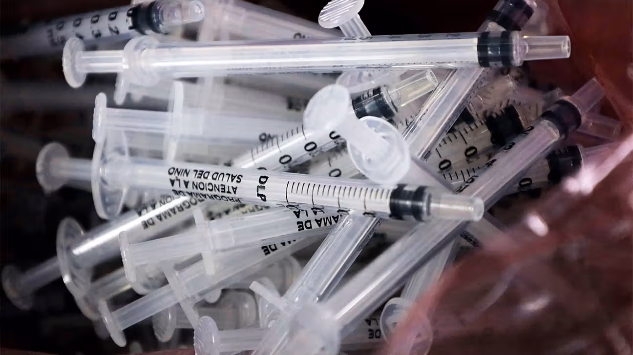 pile of single-use syringes for vaccines