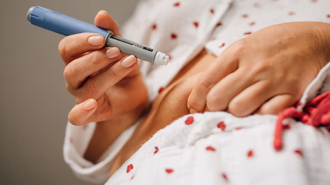 Female injecting her stomach with a GLP-1 pen