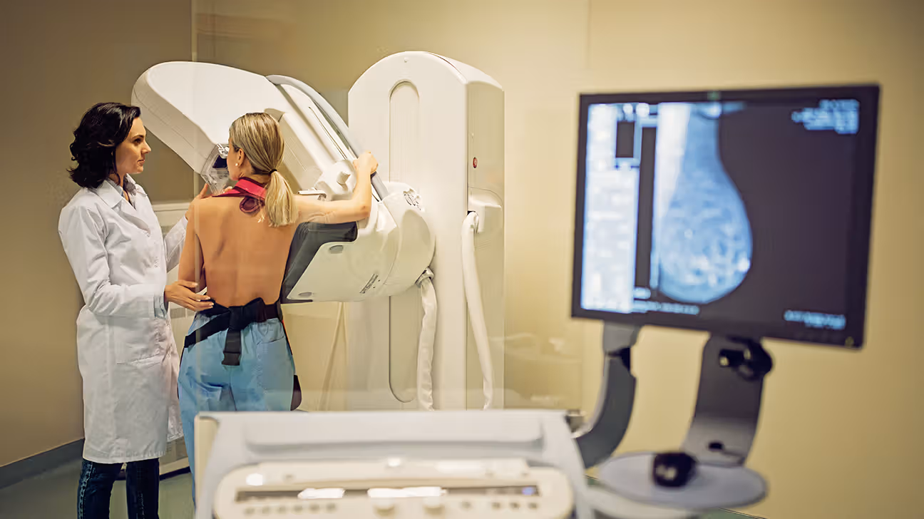 Female receives mammogram with technician