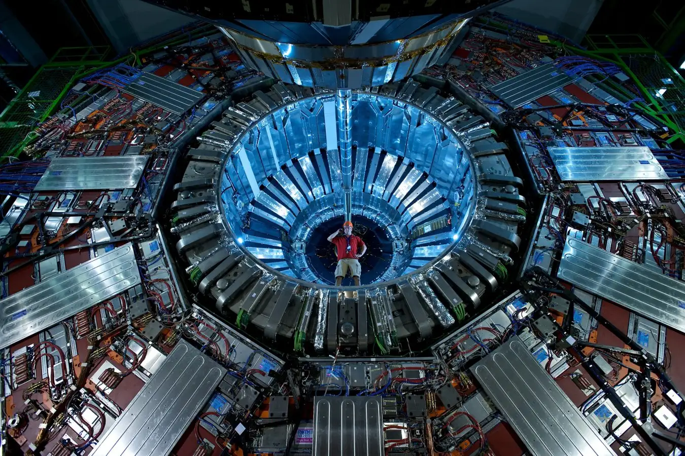Researcher standing in one end of the CMS (Compact Muon Solenoid) detector at CERN (the European particle physics laboratory) near Geneva, Switzerland, during maintenance. The CMS detector sits around the large hadron collider (LHC), CERN's highest energy particle accelerator. In July 2012 it was announced that the CMS and ATLAS (a torodial LHC apparatus) experiments at the LHC had detected a Higgs boson particle for the first time. The Higgs boson is thought to give other particles mass.