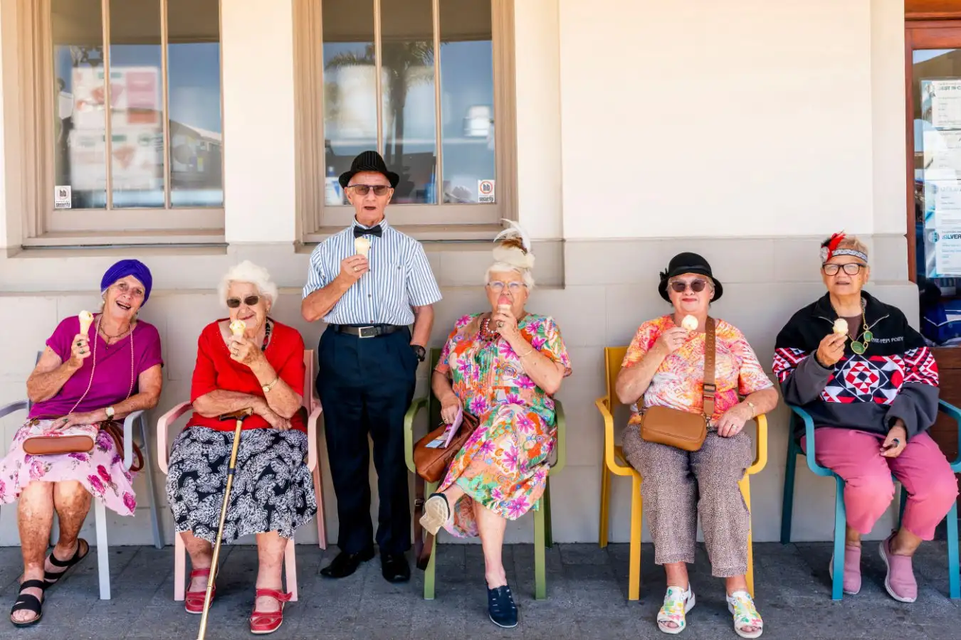 3E68RG6 A Group Of Women In Art Deco Costume Sitting Down Eating Ice Cream At The Napier Art Deco Festival, Napier, Hawke's Bay, New Zealand