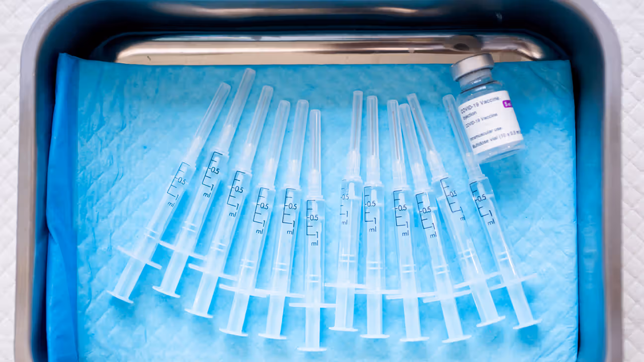COVID-19 vaccine and syringes in metal tray
