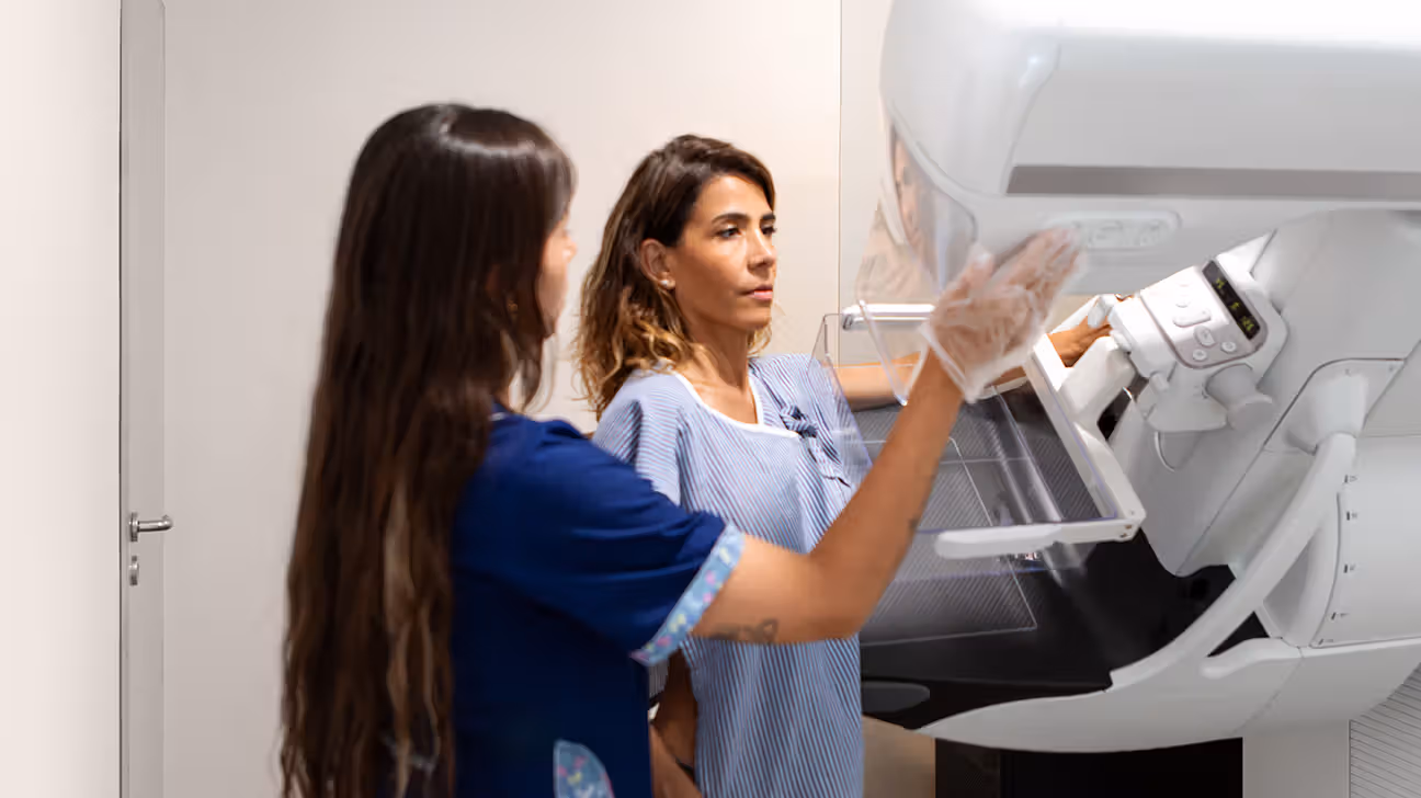 Female undergoing mammogram with technician