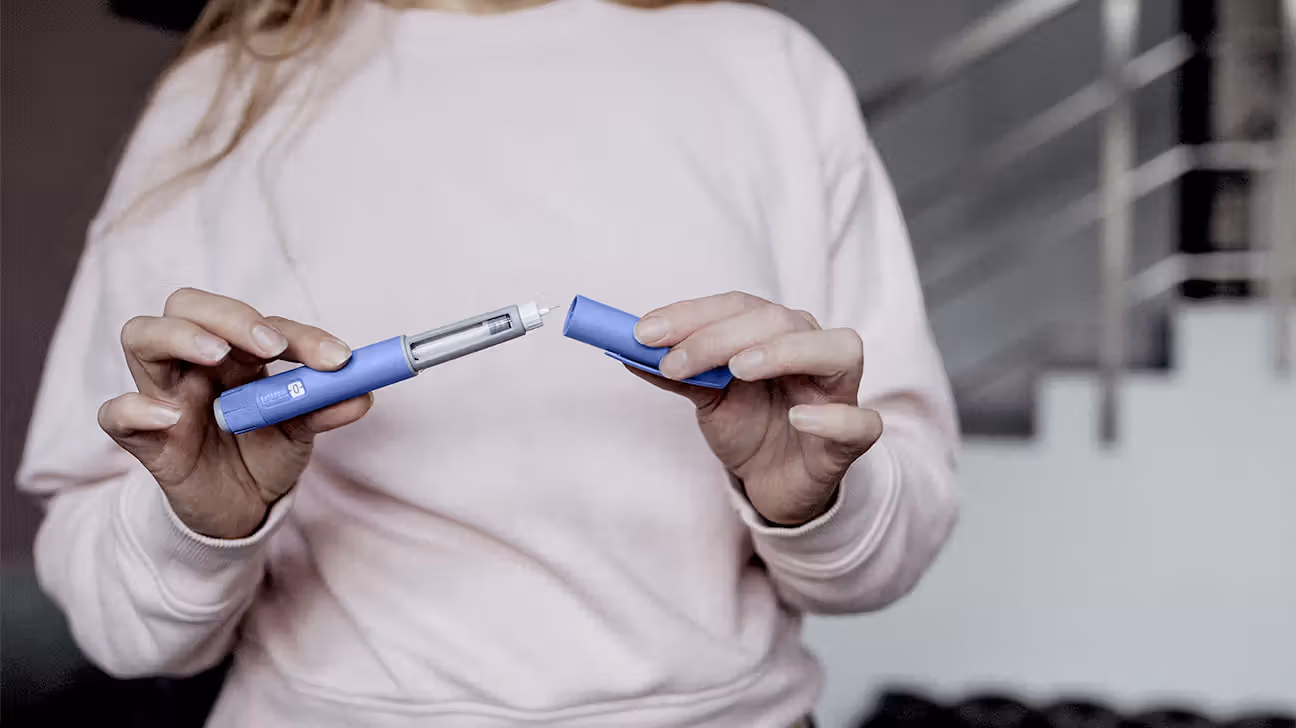 Female holding GLP-1 injection pen