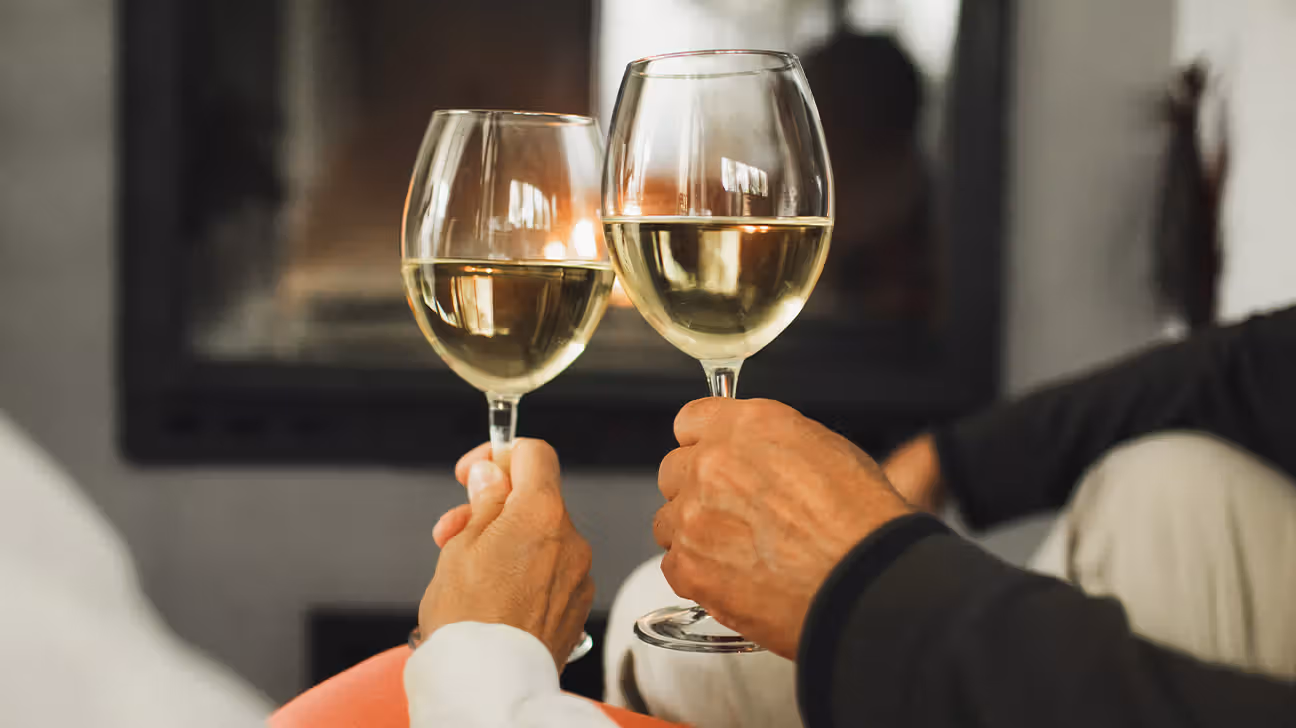 Two white wine glasses clinking together