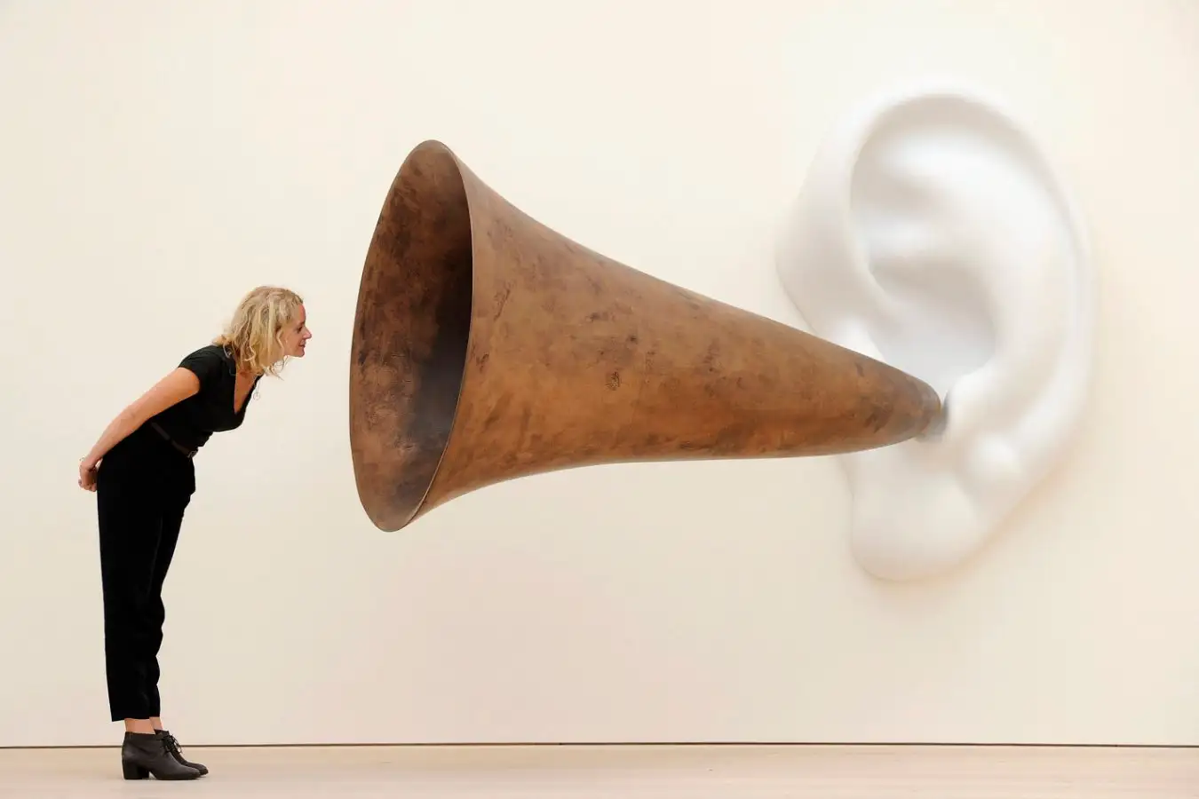 An employees poses next to an installation by US artist John Baldessari entitled 'Beethoven's Trumpet (With Ear)' at the Saatchi Gallery in central London on May 26, 2011. Forming part of 'The Shape of Things To Come: New Sculpture' exhibition, it is to be displayed from May 27-16 October 2011. AFP PHOTO/ CARL COURT (Photo credit should read CARL COURT/AFP via Getty Images)