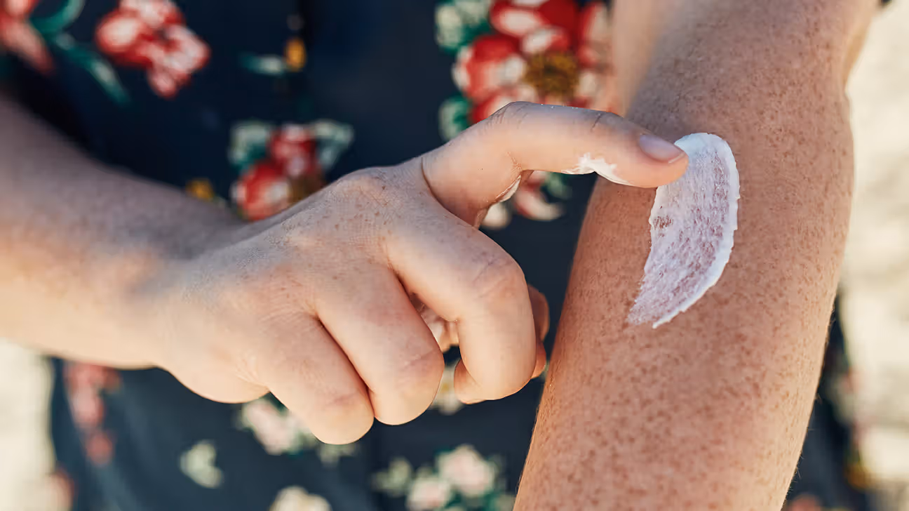 Person putting sunscreen on their arm